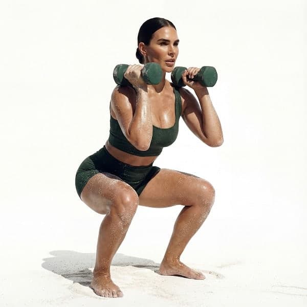 Woman performing a weighted dumbbell squat during a MokoSweat high-intensity training class at MokoBoko Studio Lisbon.