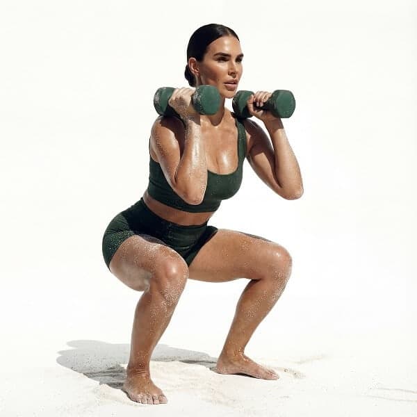 Woman performing a weighted dumbbell squat during a MokoSweat high-intensity training class at MokoBoko Studio Lisbon.